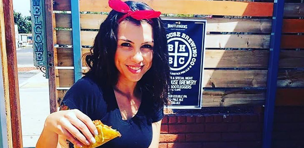 A mature woman eating a taco from Bootleggers Craft Pub