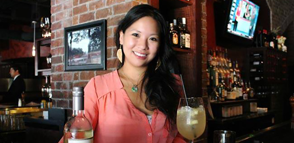 A woman having a cocktail at Kenny's