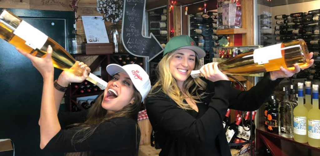 Women holding huge bottles of champagne at Luigi's Restaurant