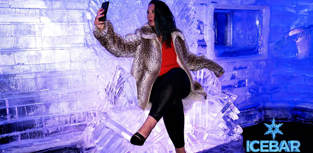 A mature woman posing on the frozen thrones at Ice Bar Orlando