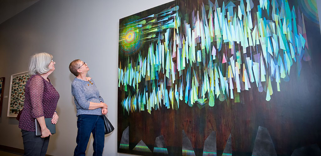 Mature women admiring a painting at Peel Art Gallery