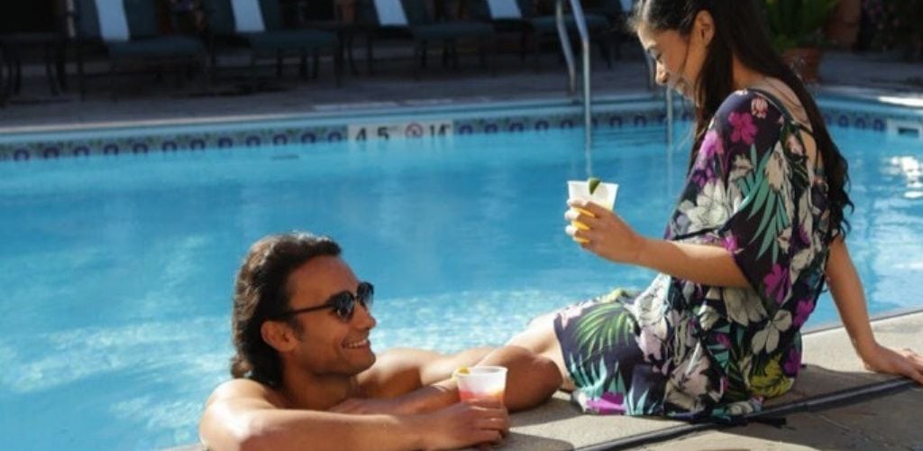 A Minneapolis MILF enjoying a drink with a man by the pool at Hotel Monteleone