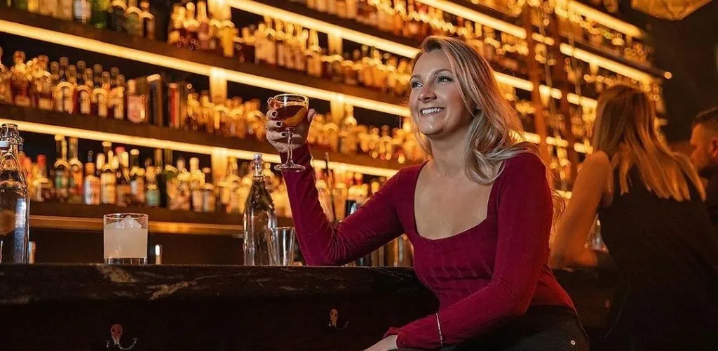 A Tulsa MILF drinking cocktail by the bar at Valkyrie Bar