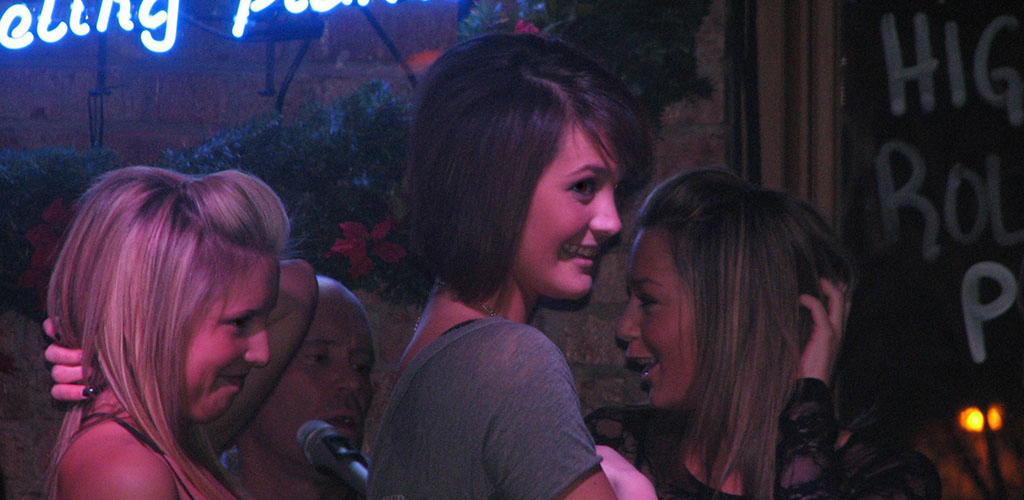 Ladies watching a performance at Michael Murphy’s Dueling Piano Bar