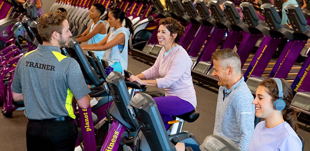 Women working out on stationary bikes at Planet Fitness