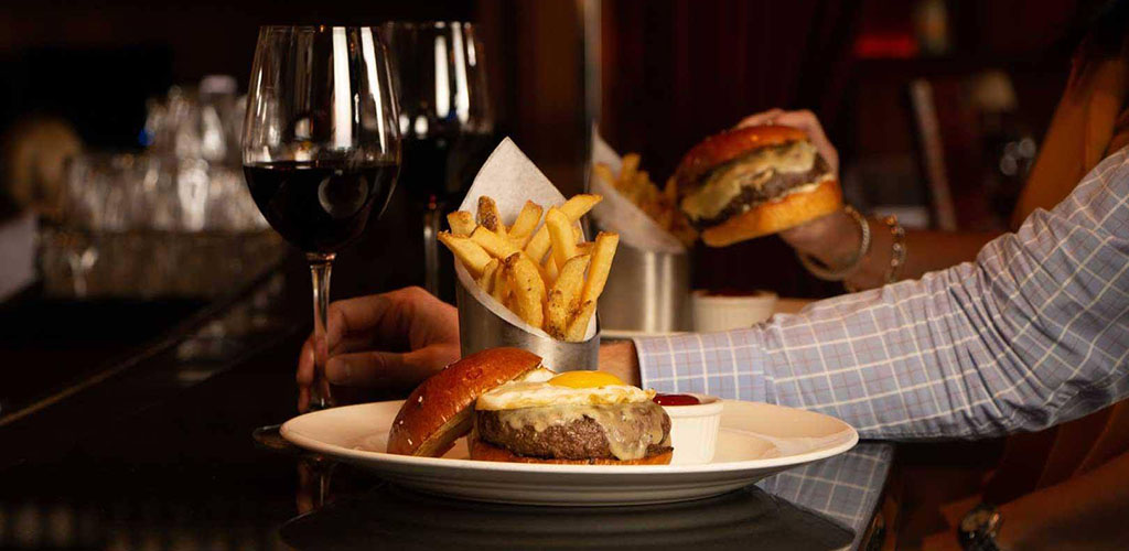 Burger with a side of fries and wine from The Capital Grille