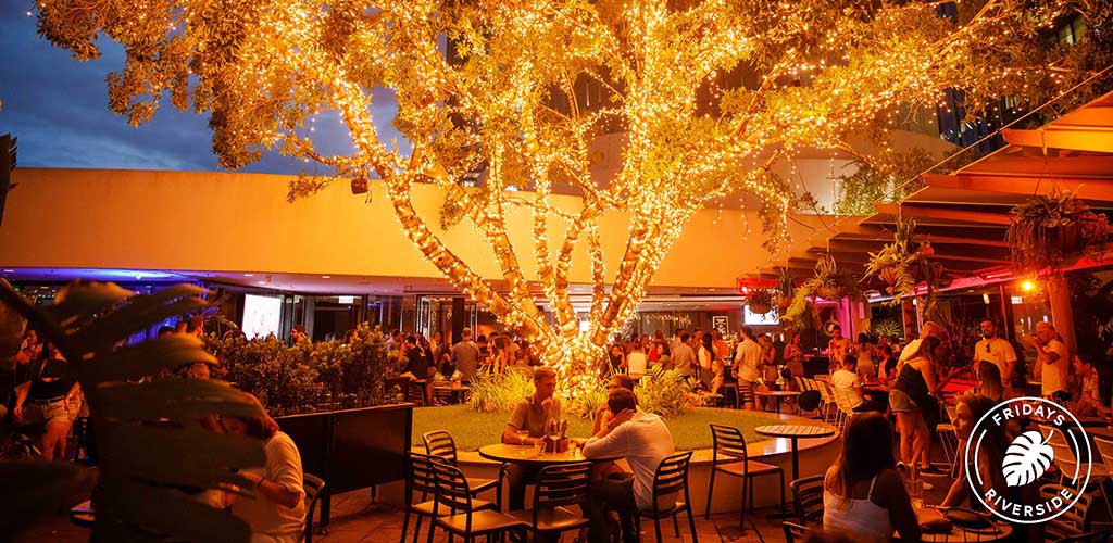 The brightly lit tree at the patio of Fridays Riverside