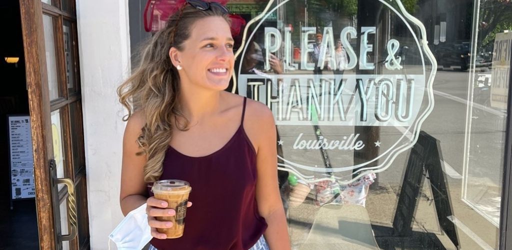 A Young Louisville drinking her ice coffee outside Please and Thank You Cafe