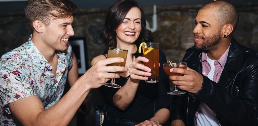 A Kansas City cougar holding drinks with two guys at Manifesto