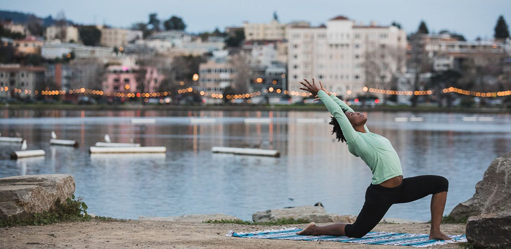 Mature woman doing yoga on the baech