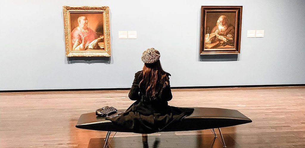 A woman admiring works by Pieter Lastman at The Art Gallery of Alberta