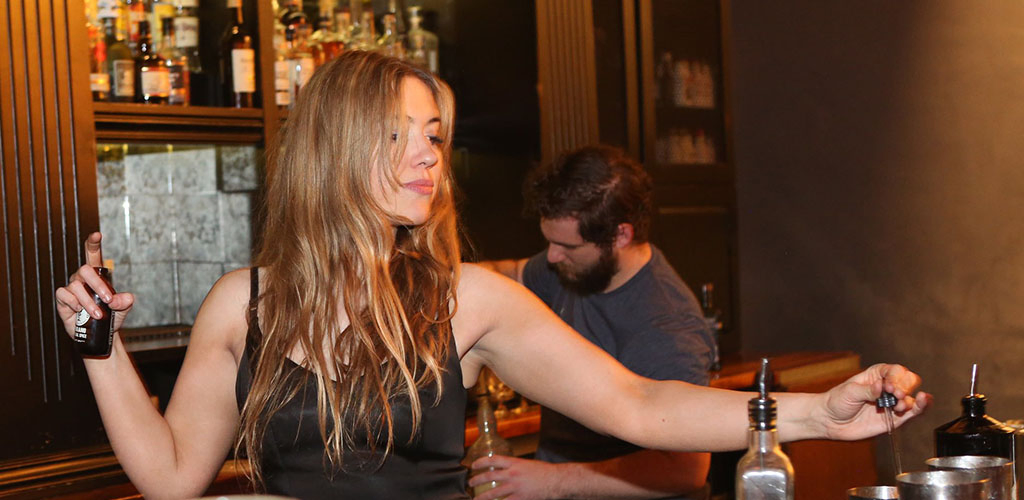 A beautiful woman mixing drinks at Bitter and Twisted