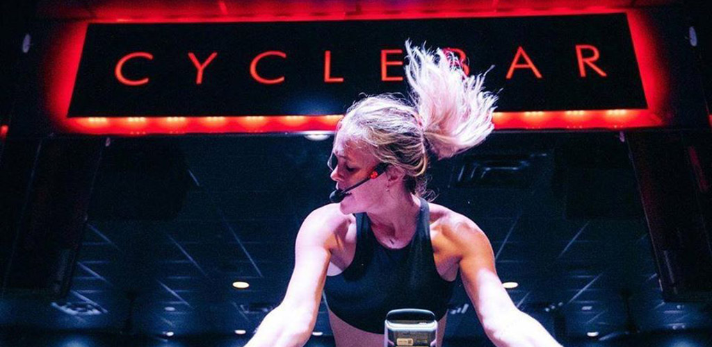 A hot woman in an intense cycling workout at Cycle Bar