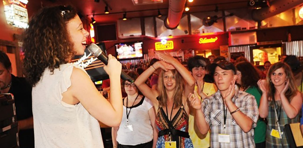 A woman singing karaoke at On the Rocks