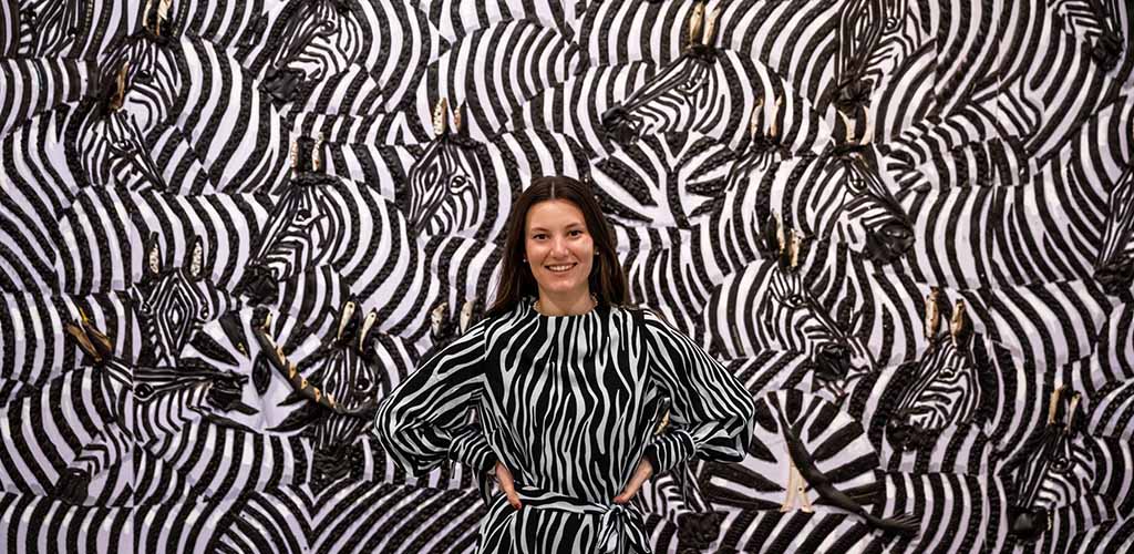 A woman posing in front of artwork at Montclair Art Museum