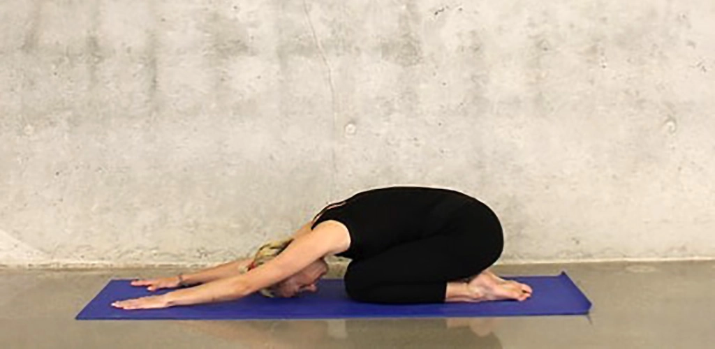 A fit woman in Balasana pose at Willow St. Yoga