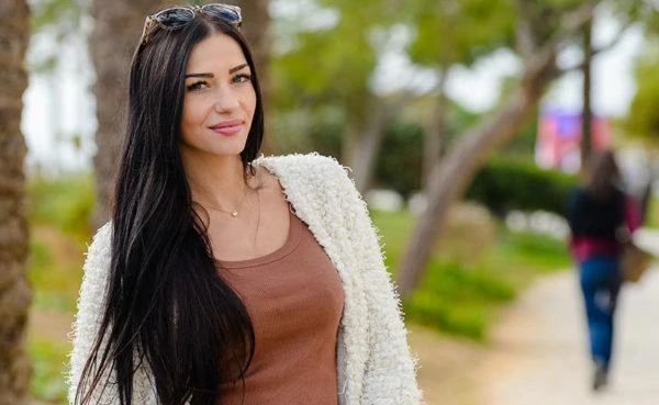 Smiling Venezuelan cougar in brown shirt