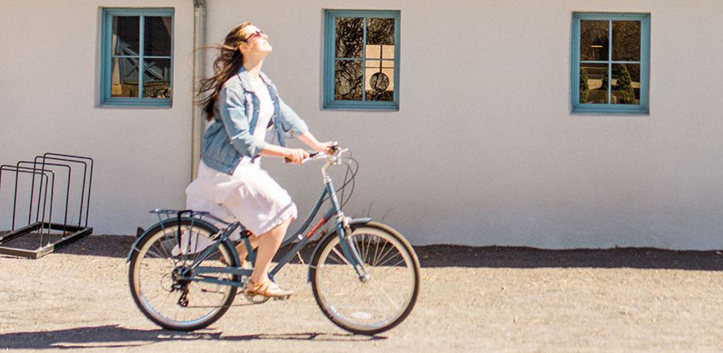 A woman riding her bike in the grounds of Los Poblanos Historic Inn and Organic Farm