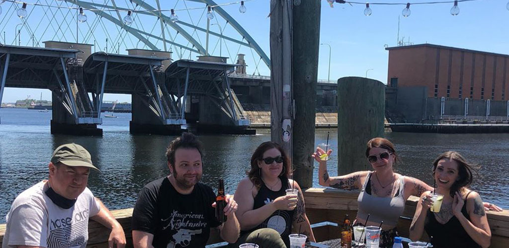 Friends hanging out by the harbor at The Hot Club