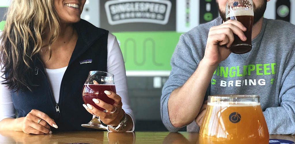 A man and woman trying out beers from Singlespeed Brewing