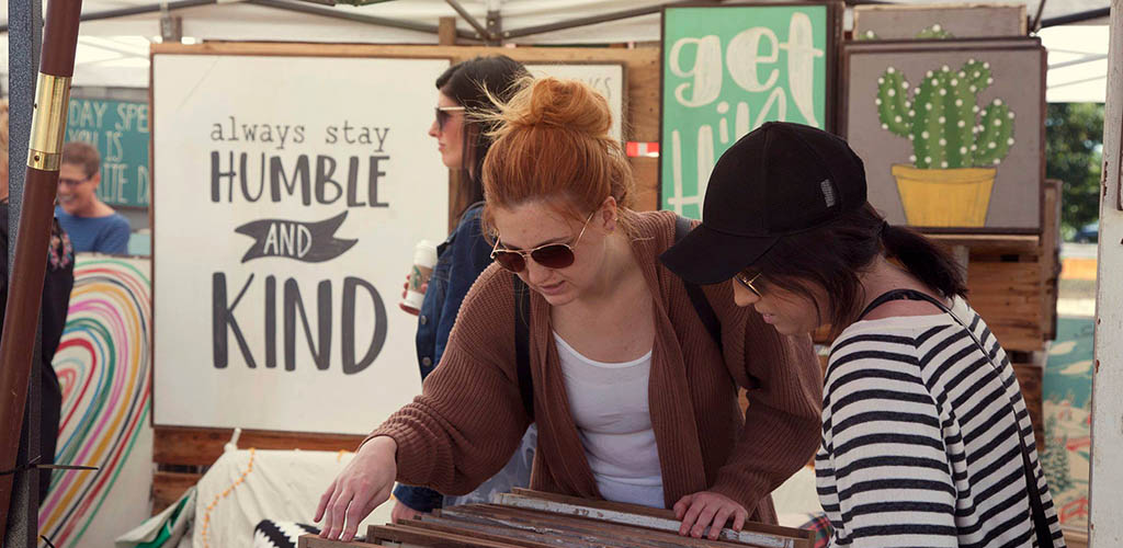 Women shopping for art at the Vintage and Made Fair