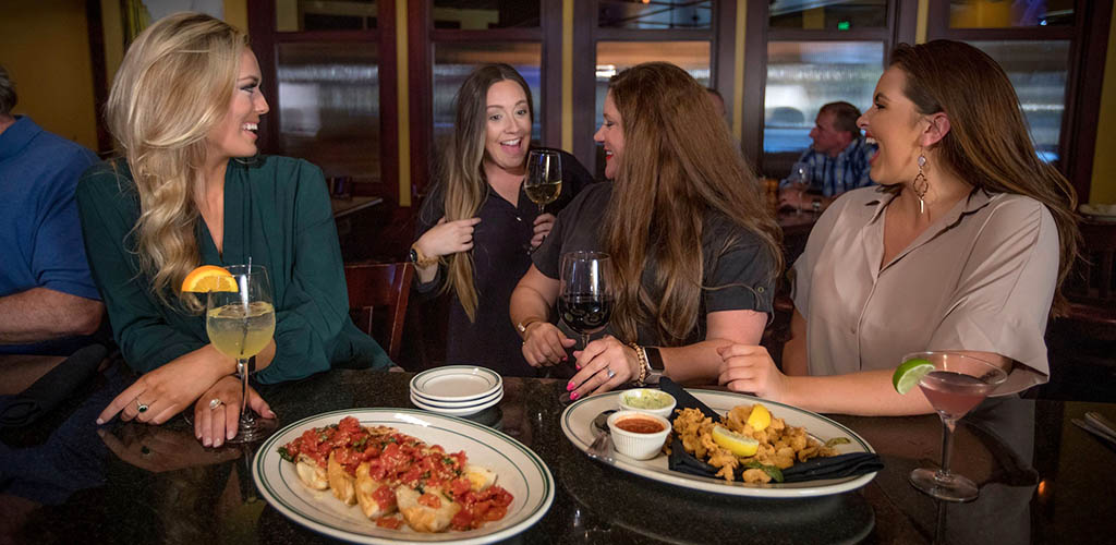 A woman running into her friends at Amerigo Italian Restaurant