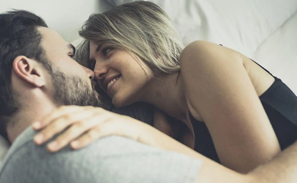 Confident man in bed with a woman