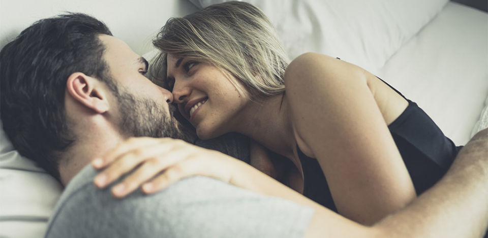 Confident man in bed with a woman