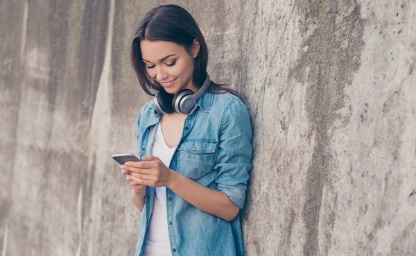 Woman wearing headphones and using the best dating apps in Detroit