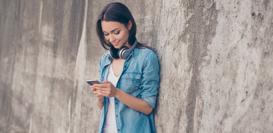 Woman wearing headphones and using the best dating apps in Detroit