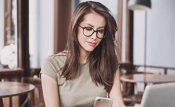 Woman in glasses using the best dating apps in Colorado Springs