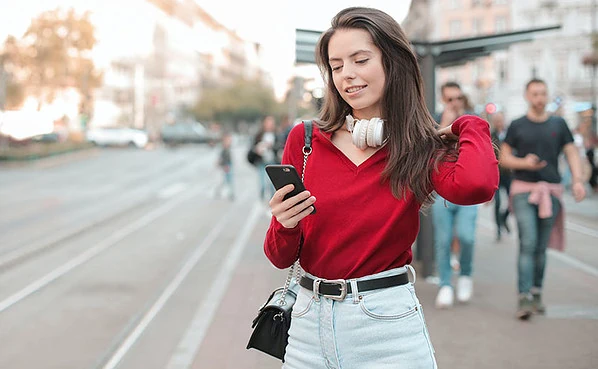 Woman checking out the best dating apps in Philadelphia while walking