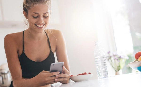 Hot girl texting in the kitchen