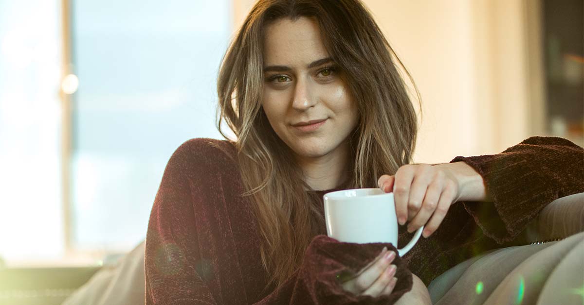 Woman on a couch smiling at a man