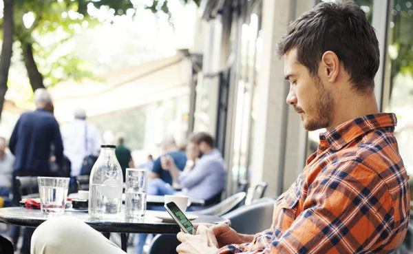 Man in a cafe learning how to respond to an ex asking how you are