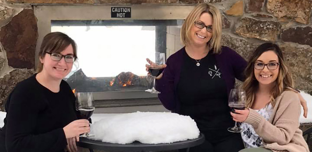 Ladies drinking wine in the snow at Corkscrew Wine and Cheese Bar