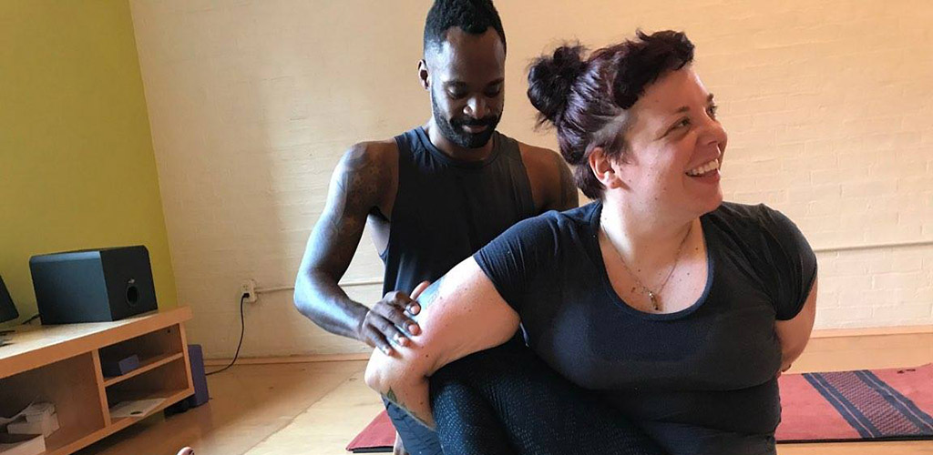 A woman trying a complex pose at Yoga Works