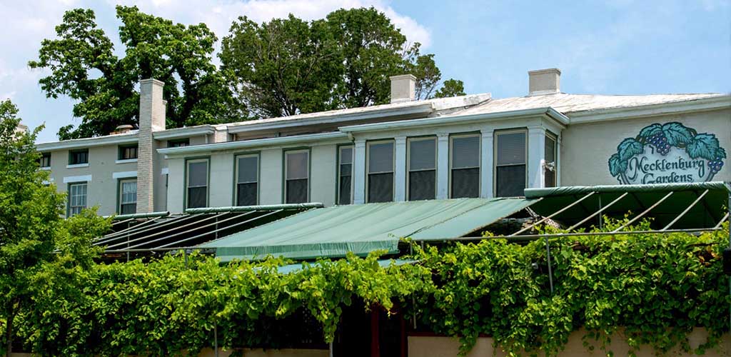 Windows and awning over a hedge row in front of a restaurant