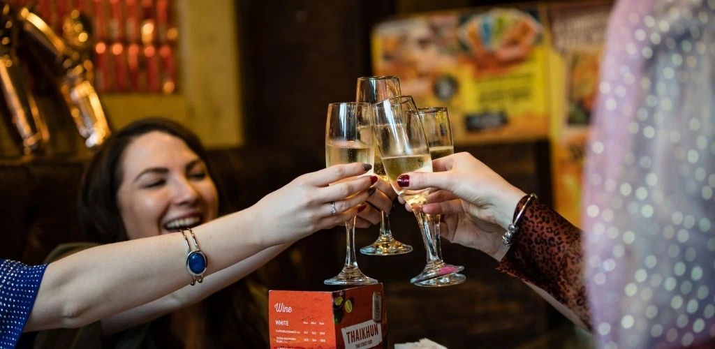 4 Liverpool singles celebrating and raising their glasses in Thaikhun