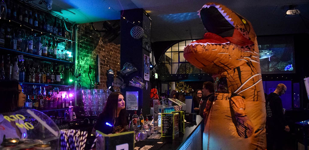 Two cute bartenders serving cocktails at a costume party in Reload Bar and Games