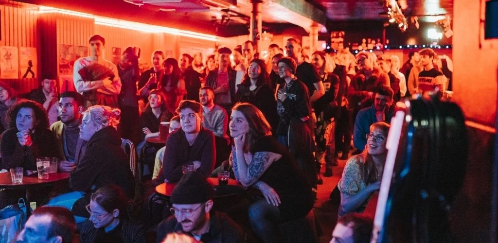 A crowd of Glasgow singles drinking and watching a comedy show at Nice N Sleazy