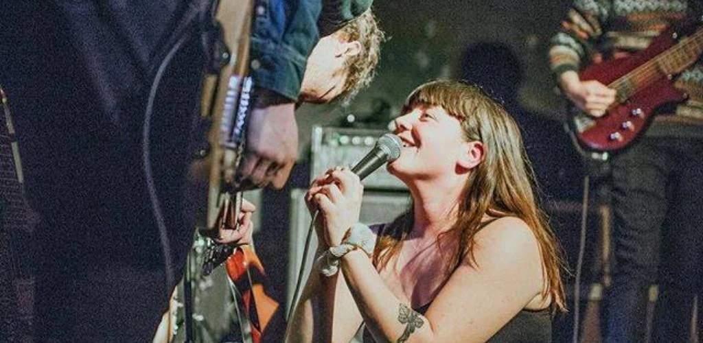 A band singing at a live event at Mulburrey Coffeehouse in Hamilton