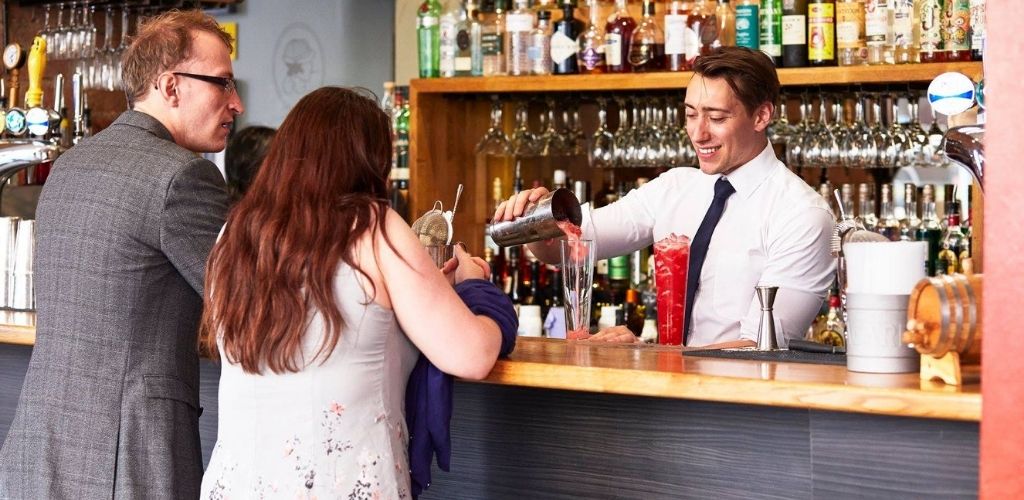 A cute Leicester couple drinking martini at the bar at Manhattan34