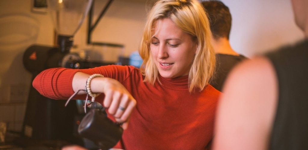 A cute barista sipping coffee at Fortitude Coffee in Manchester