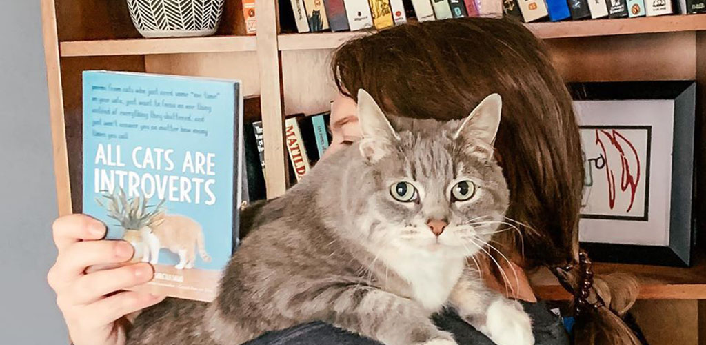 A cute cat with a cool book from Watermark Books and Cafe