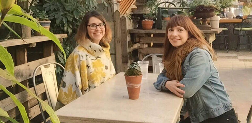 Friends enjoying drinks amid plants at Greenhouse Bar