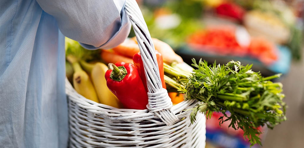 Single woman holding a grocery store basket