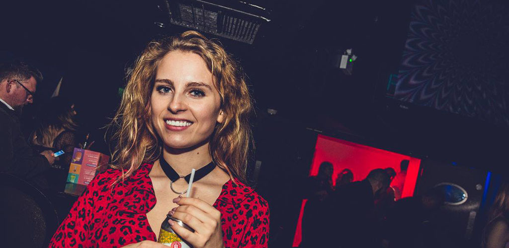 A beautiful woman holding a drink at Fiction