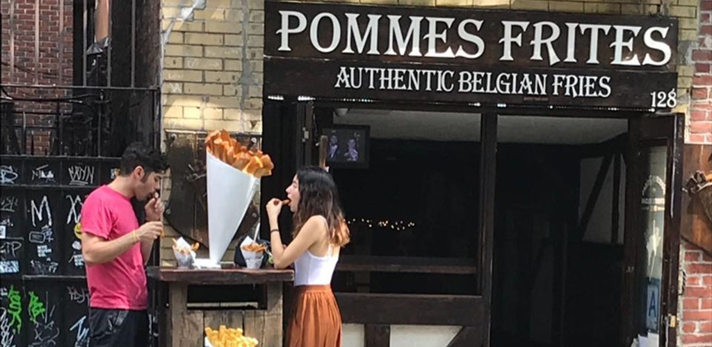 A young man and woman in front of Pommes Frites