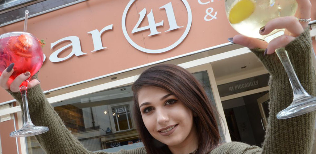 Cute woman holding cocktails in front of Bar 41